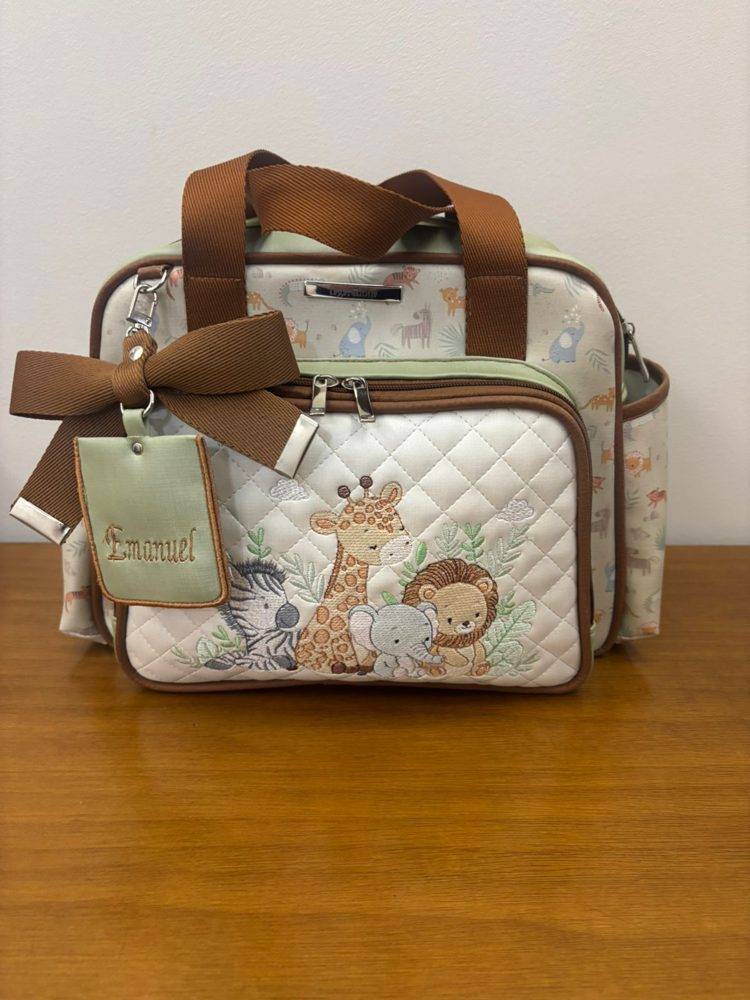 Bolsa maternidade safári com bordado de animais e tag com o nome Emanuel